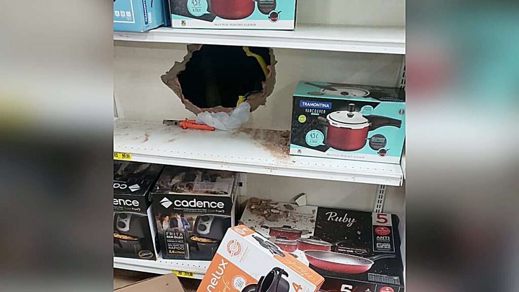Ladrão usa picareta, abre buraco na parede de loja para roubar e foge com disparo de alarme