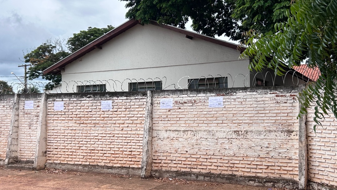 Professores pregam cartazes no muro da escola para conscientizar motoristas a n&atilde;o estacionar na cal&ccedil;ada